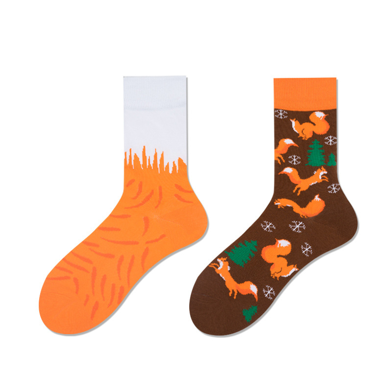 A pair of orange and brown socks with animal patterns, featuring a fox on one side and a green forest-like design on the other.