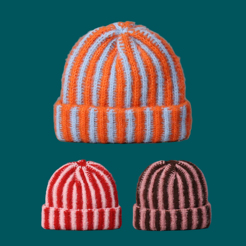 Three striped beanie caps on a two-tone background