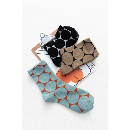 Three pairs of patterned socks on a white background
