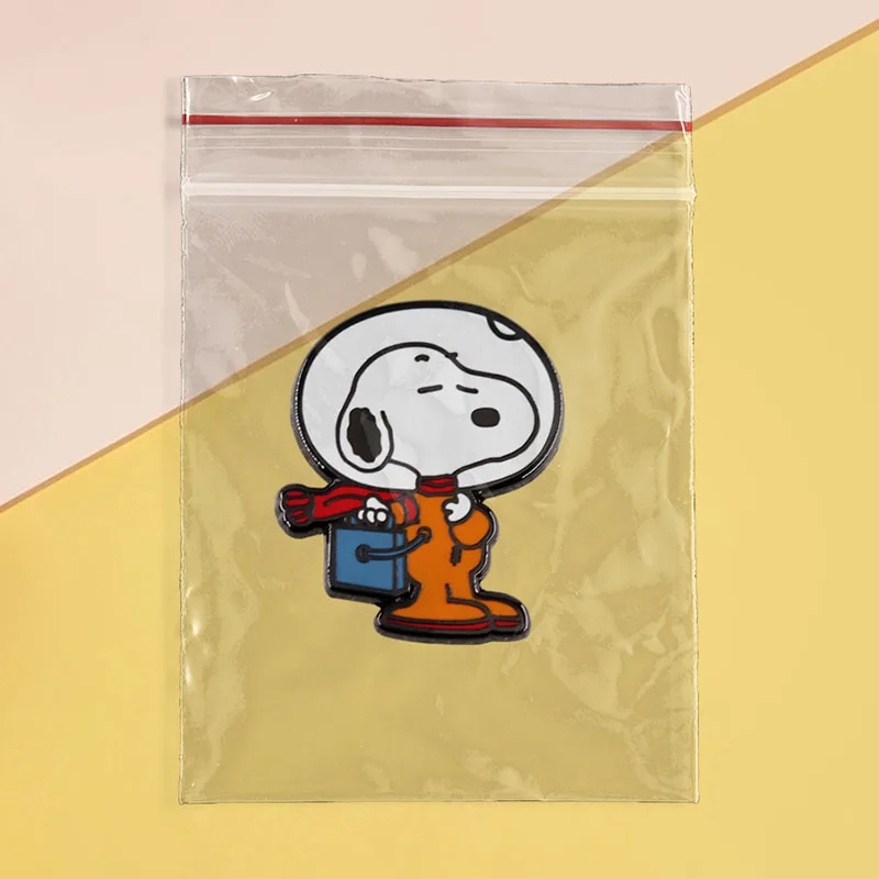 Cartoon character patch in a clear plastic bag on a yellow and pink background