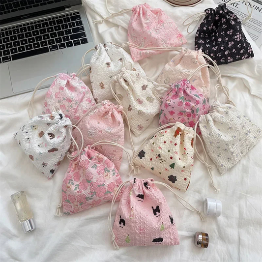 Collection of small drawstring bags with floral patterns on a white surface.