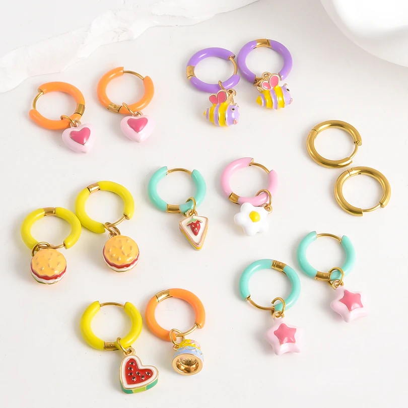Colorful hoop earrings with various charms on a white background