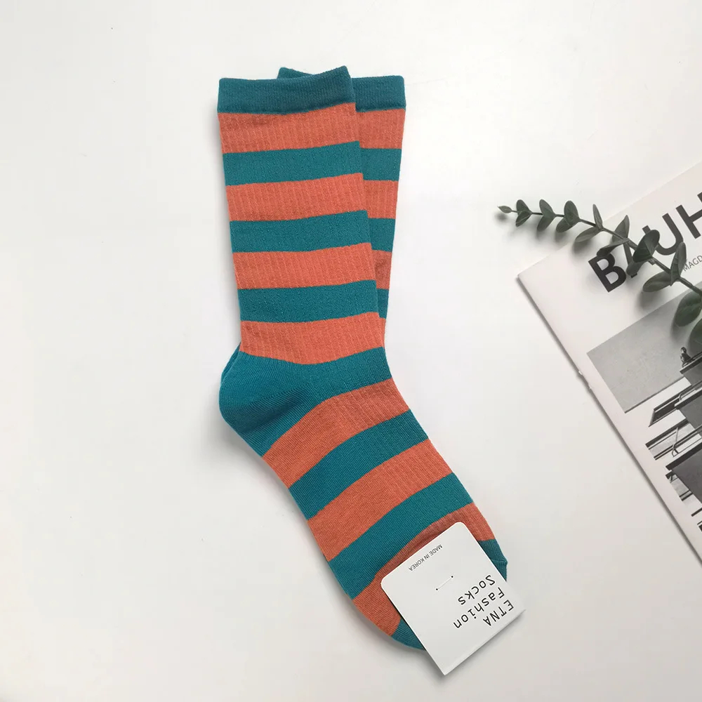 Striped socks with a visible brand tag on a white surface