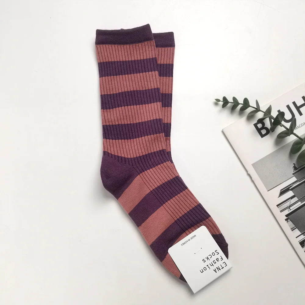 Pair of striped socks with a visible brand tag on a light background
