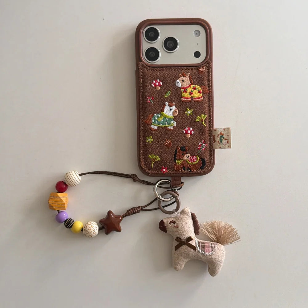 Phone case with horse design and keychain on a light gray background