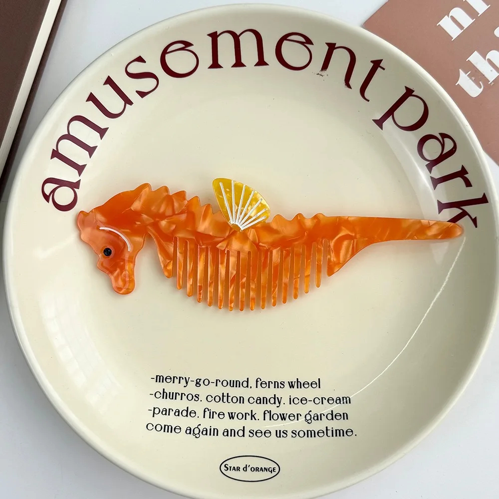 Orange fish-shaped comb on a plate with 'amusement park' text