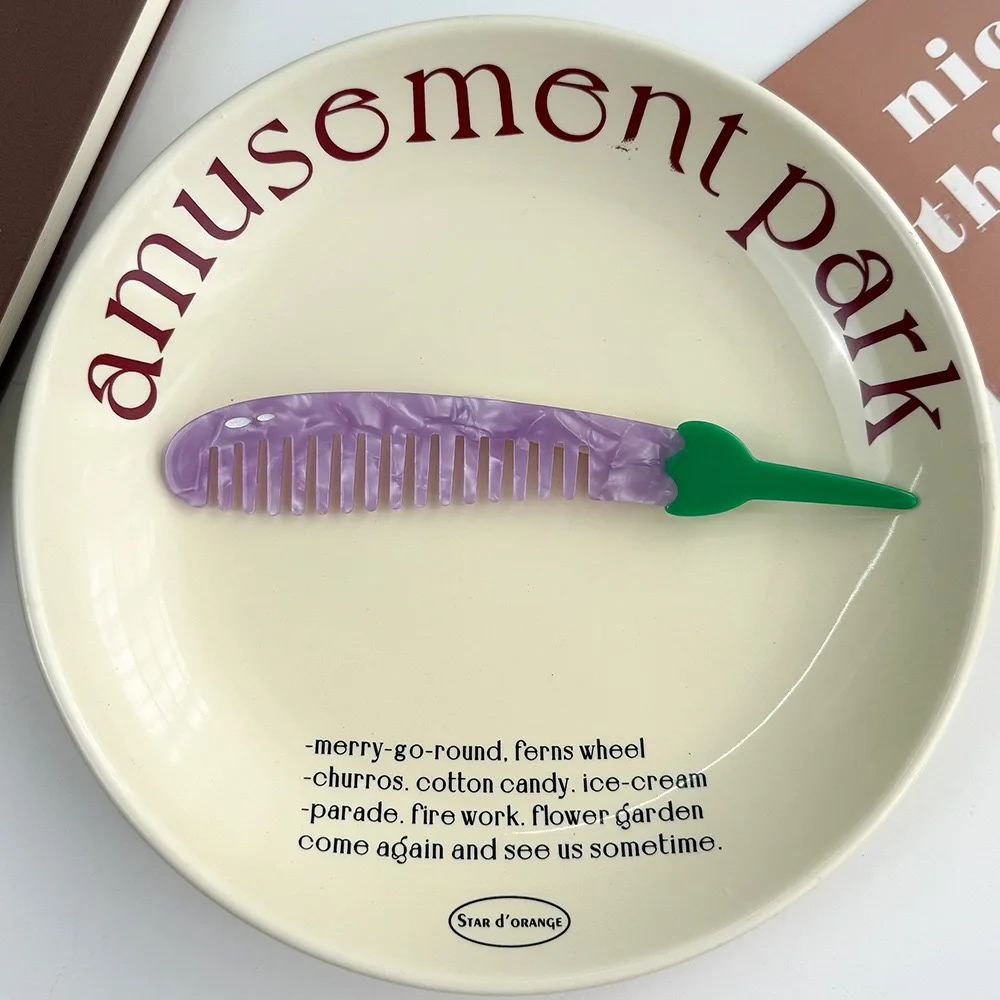 Decorative plate with 'amusement park' text and a purple comb on a white background