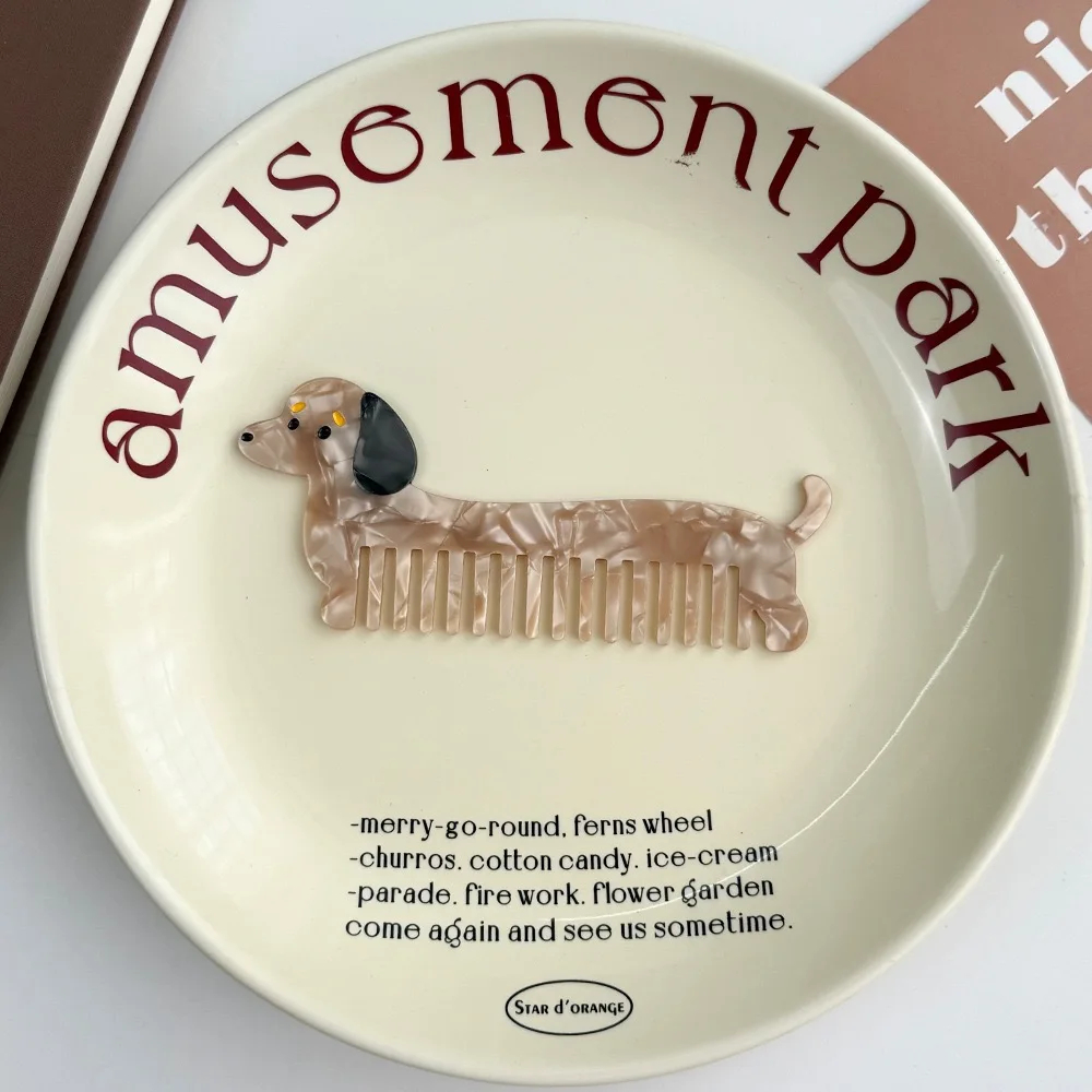 Decorative comb with a dachshund design and 'amusement park' text on a white background.