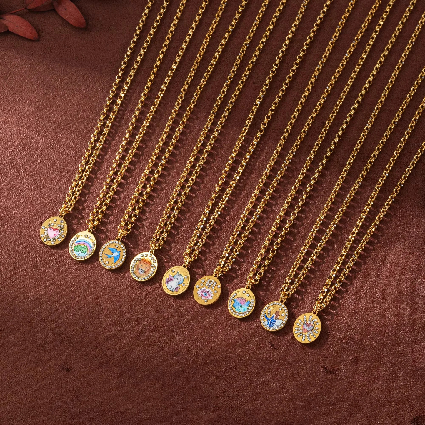 Gold necklaces with circular pendants on a brown textured surface