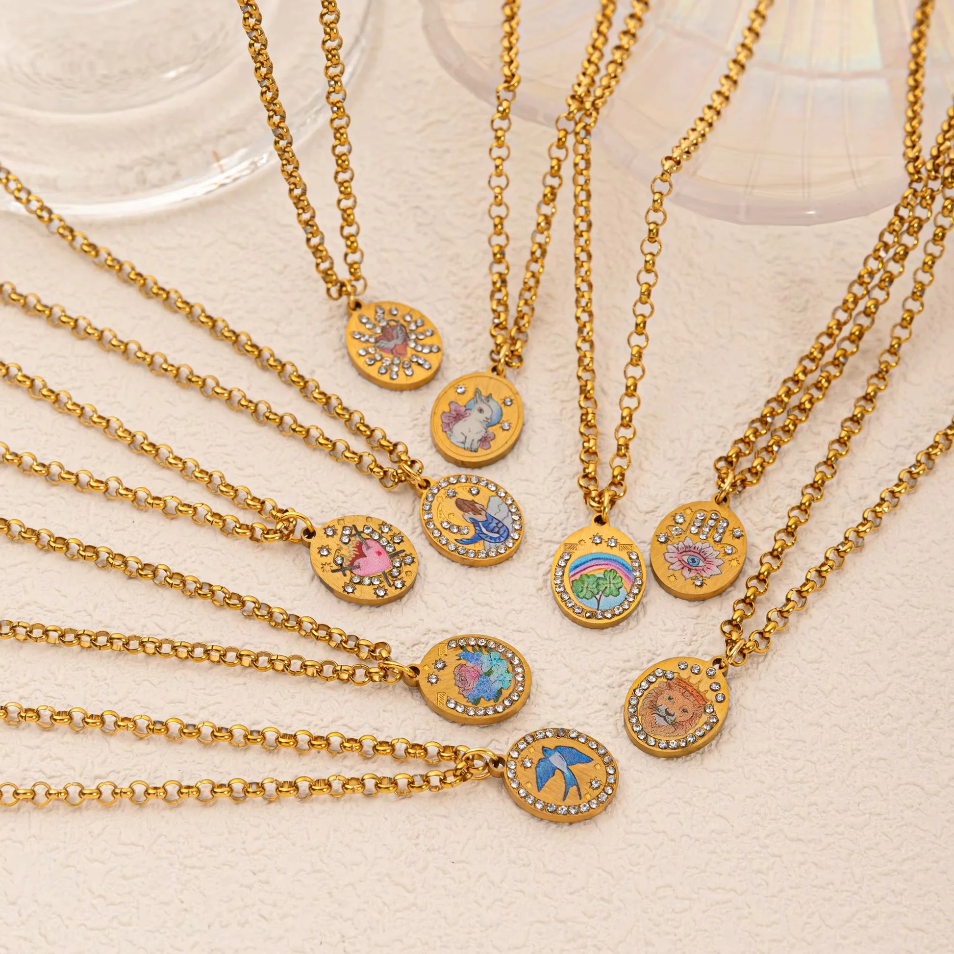 Gold necklaces with colorful pendant charms on a light background