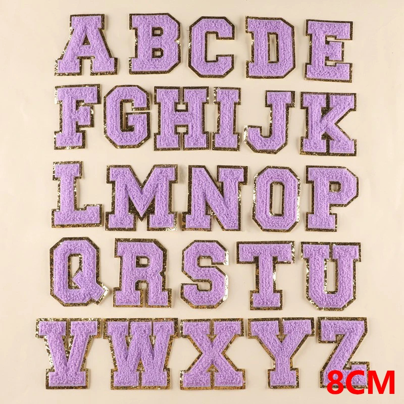 Purple letters of the alphabet patches on a beige background