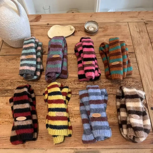 Collection of colorful striped skinny scarves on a wooden surface