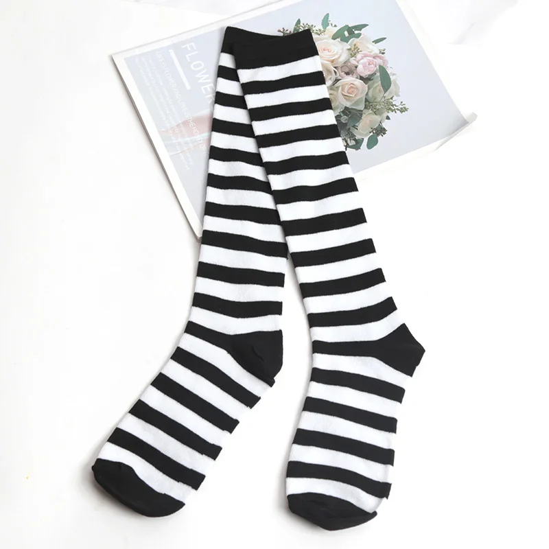 Black and white striped knee-high socks on a magazine with floral design.