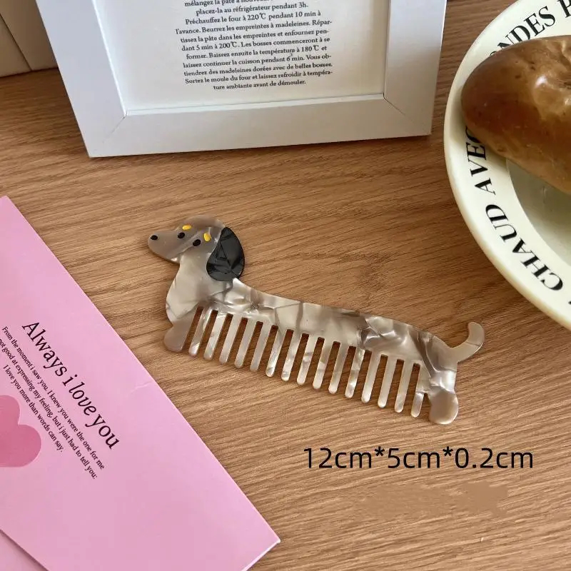 Dog-shaped comb on a wooden surface with a pink card and bowl in the background