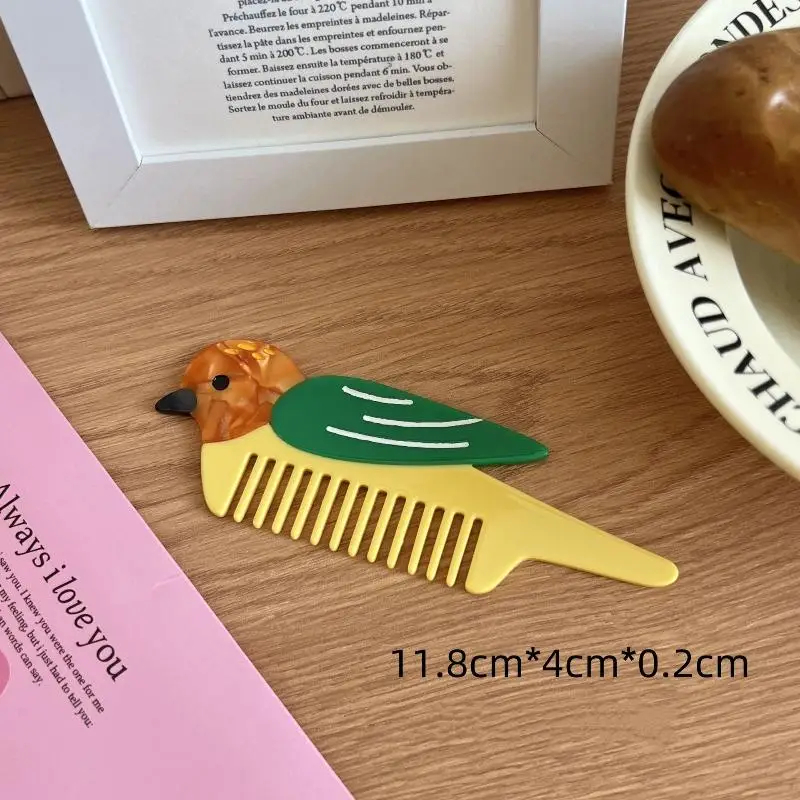 Bird-shaped comb on a wooden surface with text and a pink book in the background