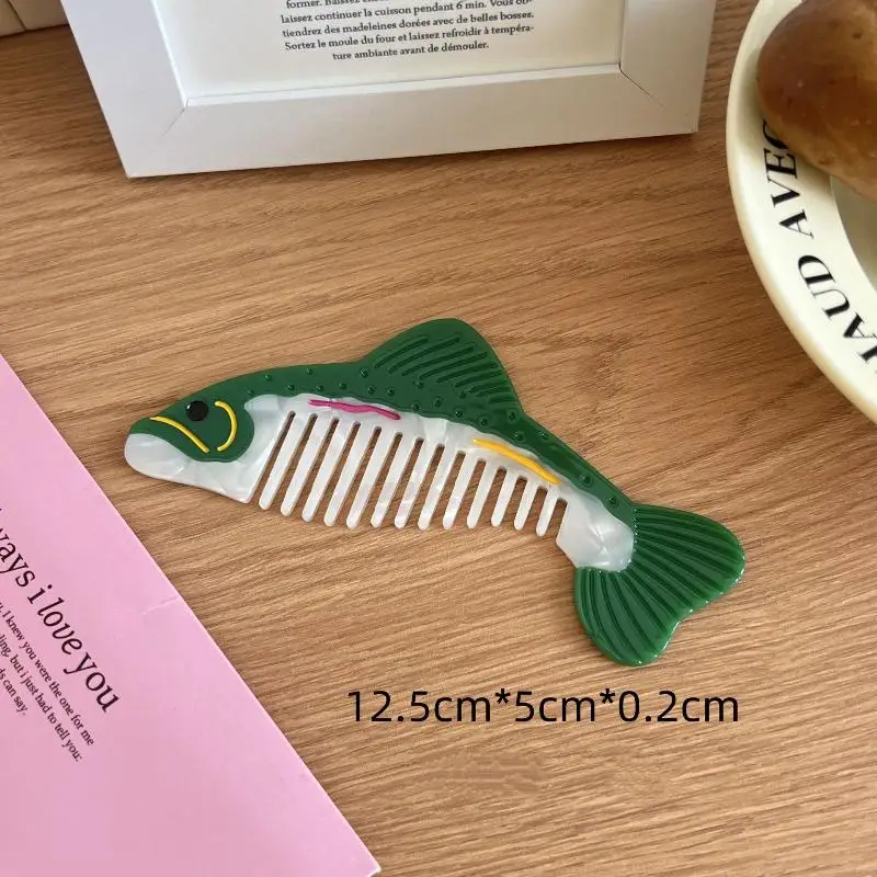 Fish-shaped comb on a wooden surface with dimensions displayed