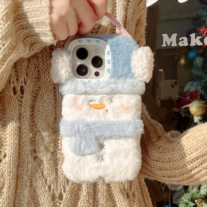 Phone case shaped like a snowman held by a person wearing a textured sweater.