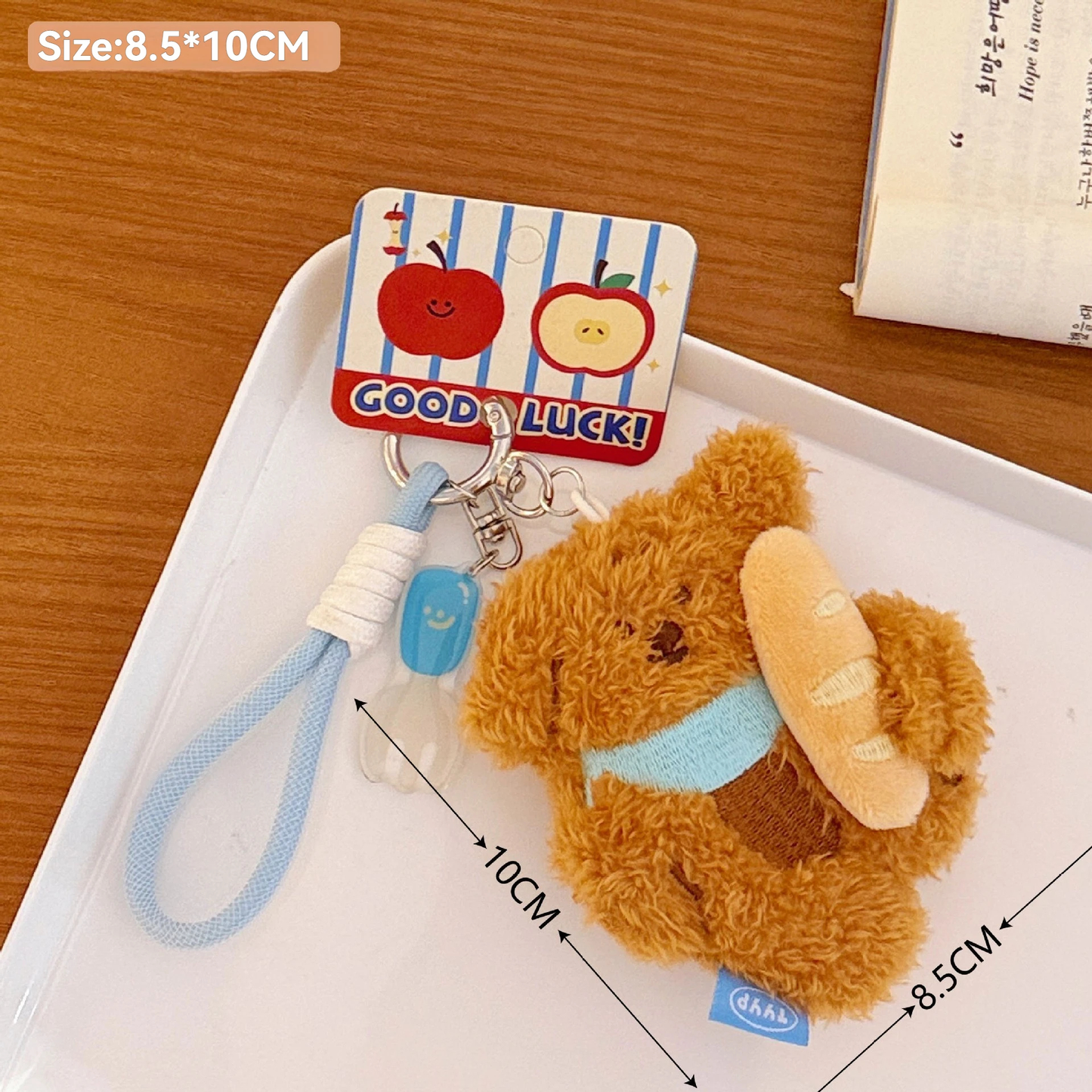Plush puppy keychain with bread on a white tray, with dimensions indicated.