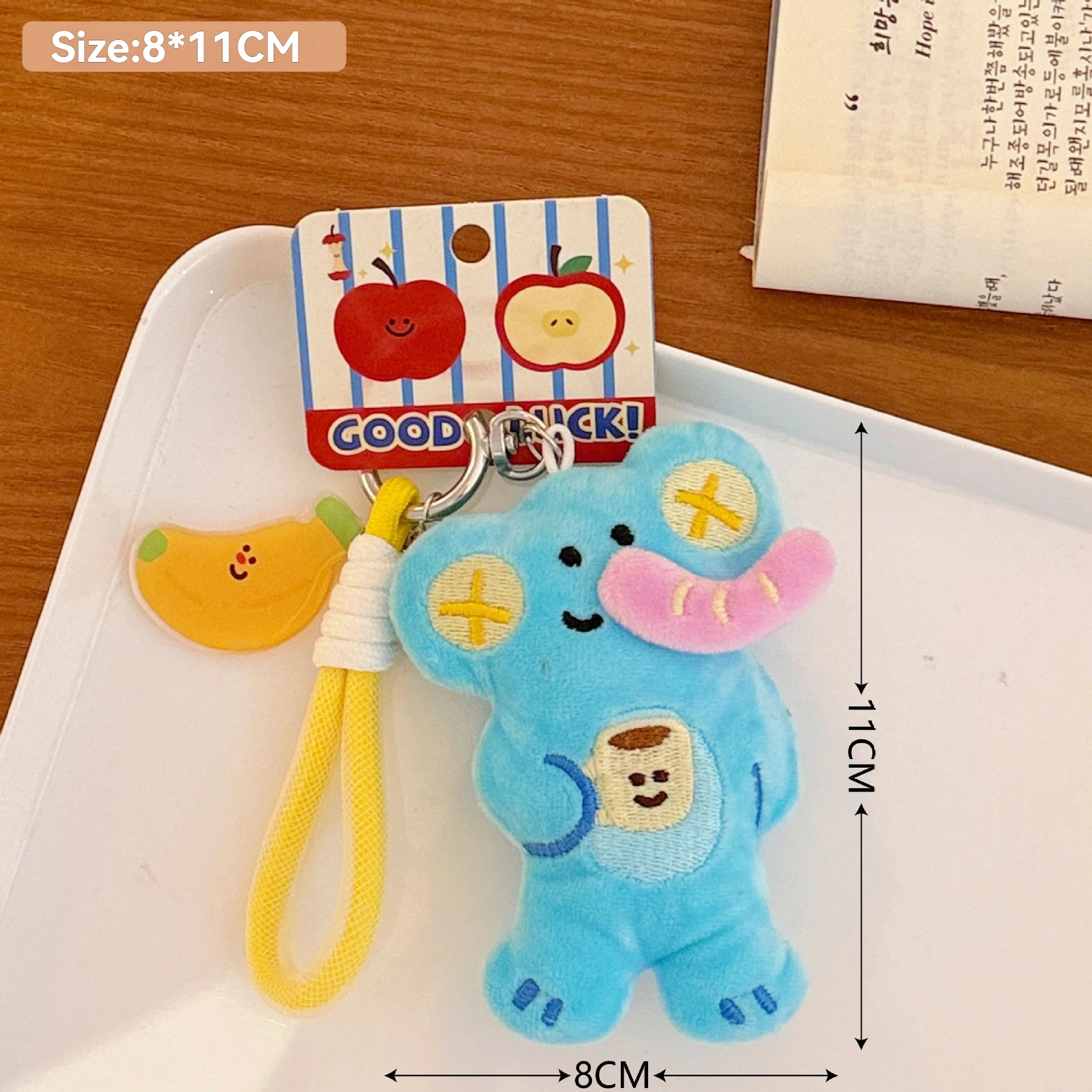 Blue cartoon elephant character keychain with a yellow strap on a white card, with dimensions indicated.