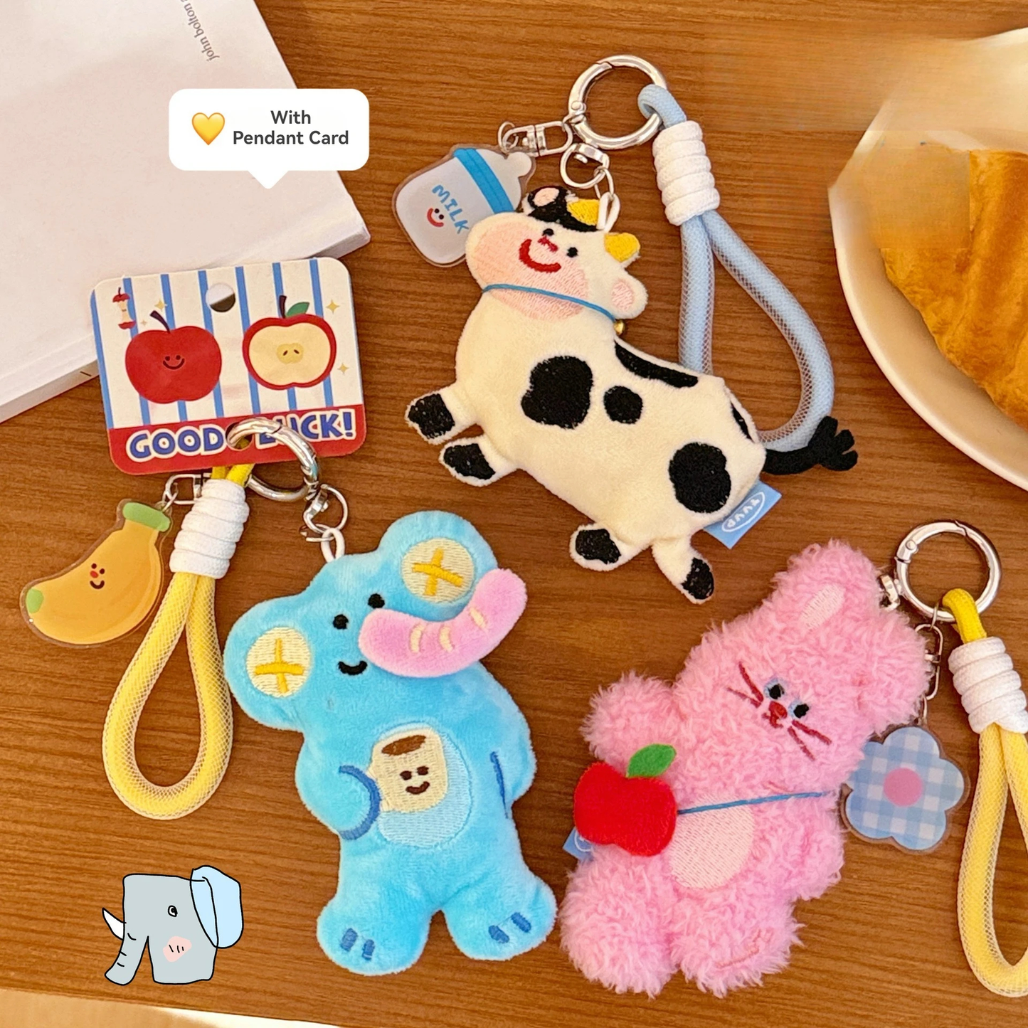 Set of cute plush keychains on a wooden surface with a pendant card.