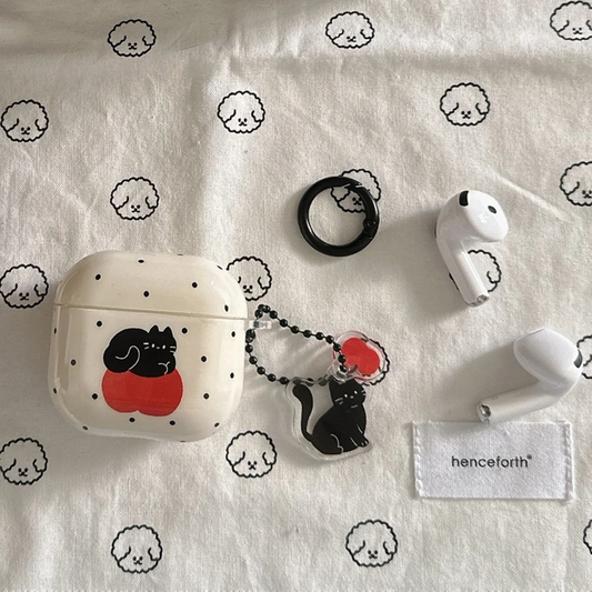 White wireless earbuds case with black cat design on a white background with sheep patterns
