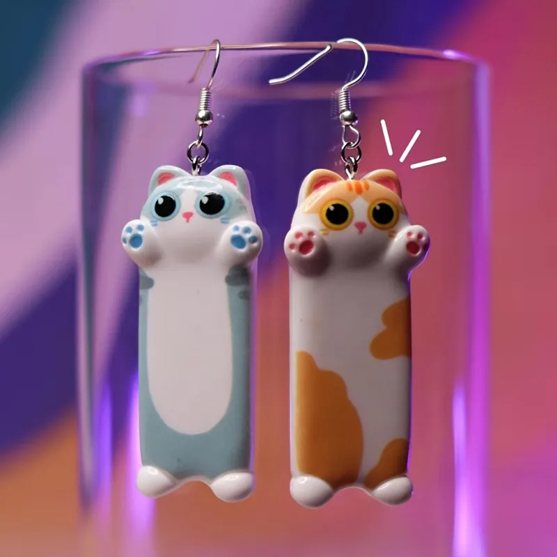 Cat-shaped earrings on a clear stand with a colorful background