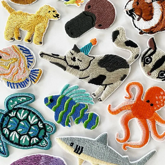 Collection of embroidered animal patches on a white background