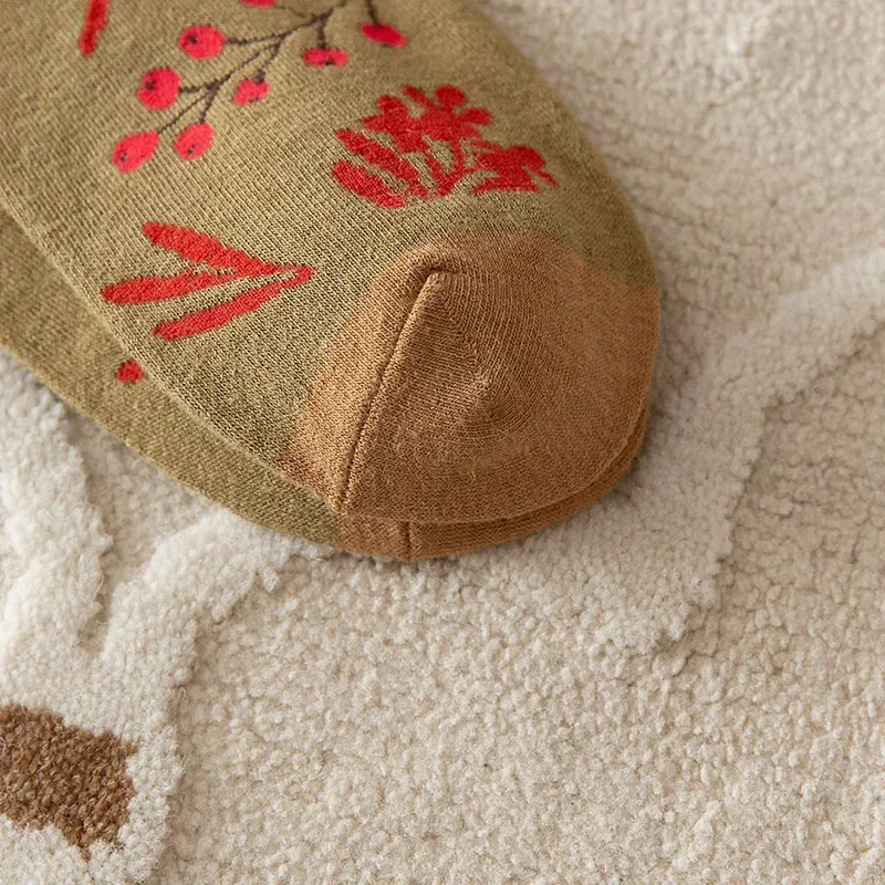 Tan sock with red floral patterns on a textured beige surface