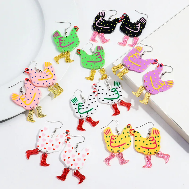 Colorful chicken-shaped earrings on a white surface