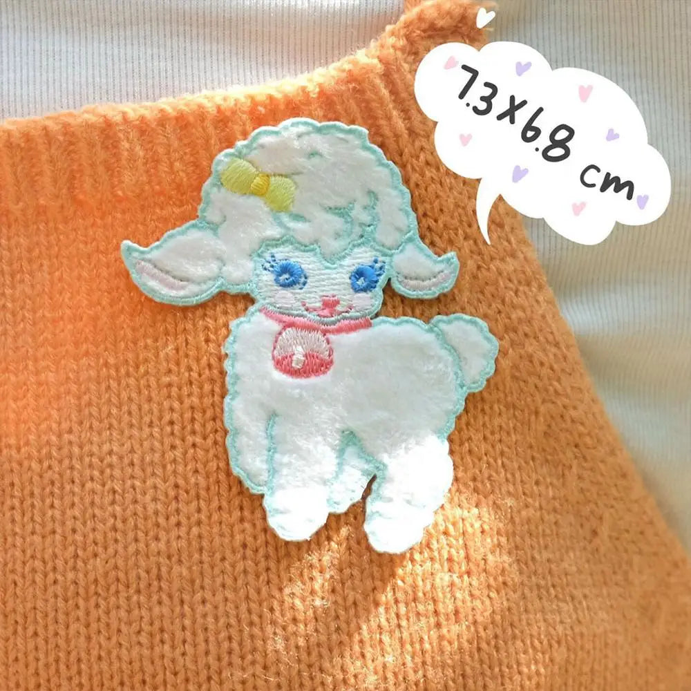 Embroidered sheep patch on an orange fabric background with size label.