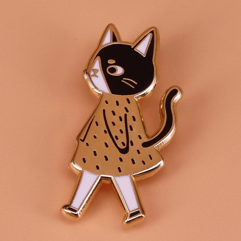 Cat-shaped pin with a gold dress on a beige background