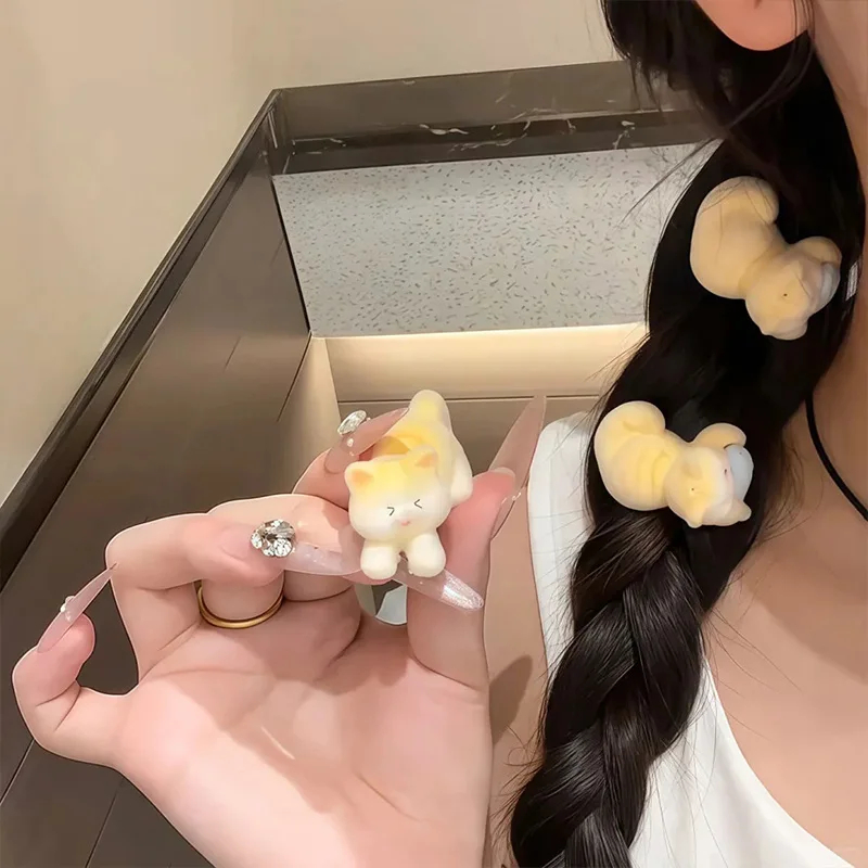 Person with braided hair wearing cloud-shaped hair ties, holding one in front.