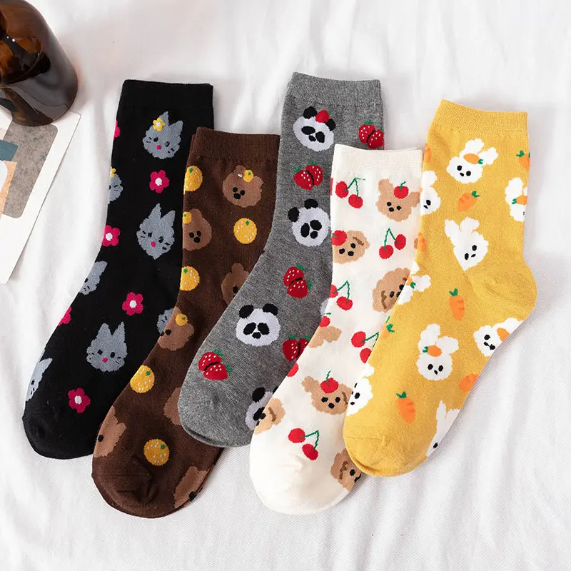Five pairs of colorful patterned socks on a white surface