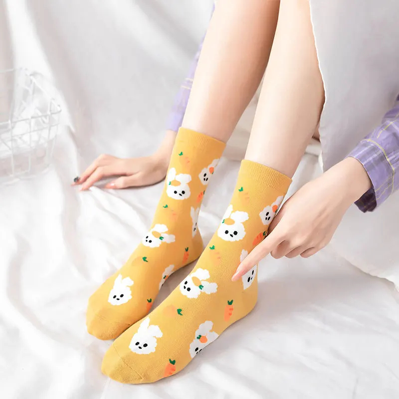 Yellow socks with cartoon designs worn by a person on a white background