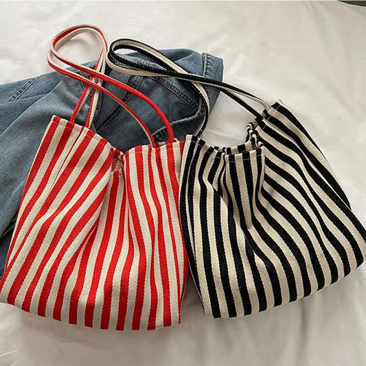 Two striped bags, one red and white, one black and white, on a light background.
