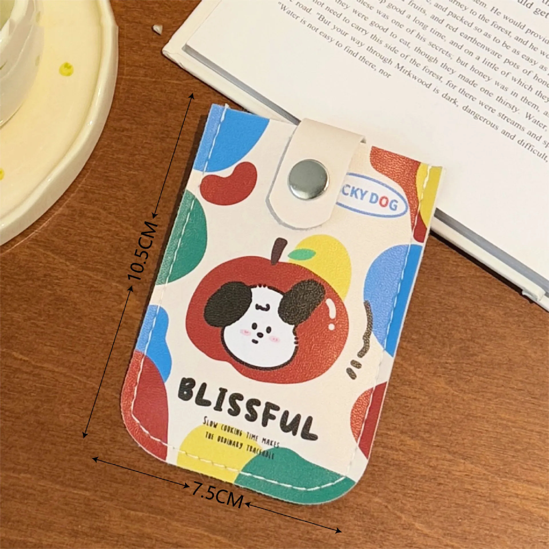 Colorful dog-themed product with dimensions on a wooden surface