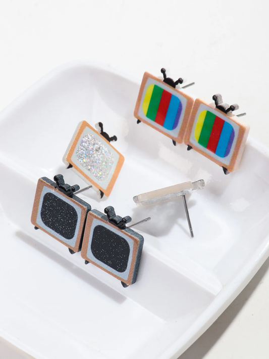 Set of earrings shaped like miniature TVs on a white surface