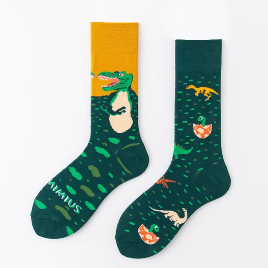 A pair of crew socks with one featuring a green dinosaur print and the other with a yellow dinosaur print, both with a matching green and yellow color scheme.