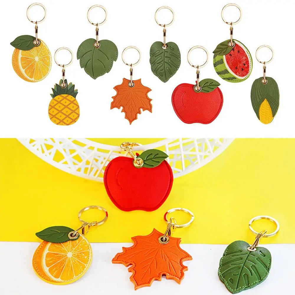 Set of colorful fruit-themed keychains on a yellow and white background