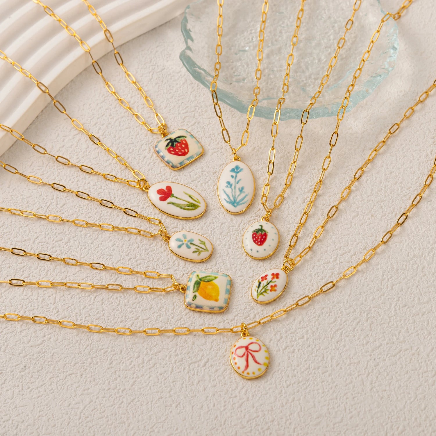 Gold necklaces with various pendants on a light background