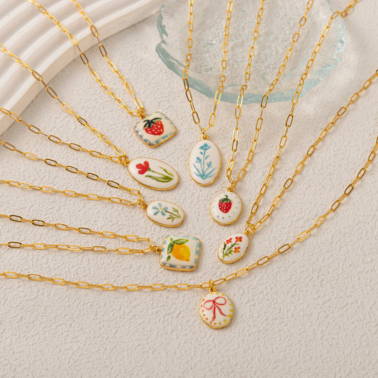 Gold necklaces with various pendants on a light background