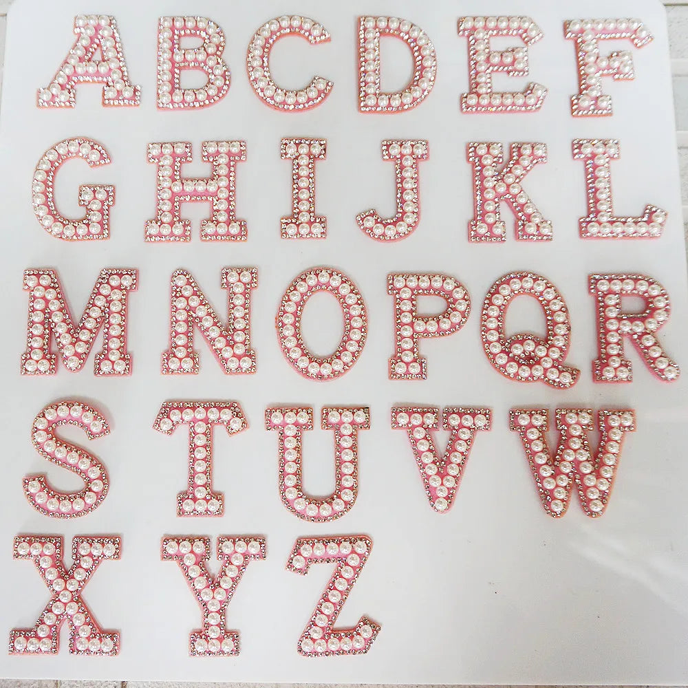Alphabet letters with rhinestone embellishments on a white background
