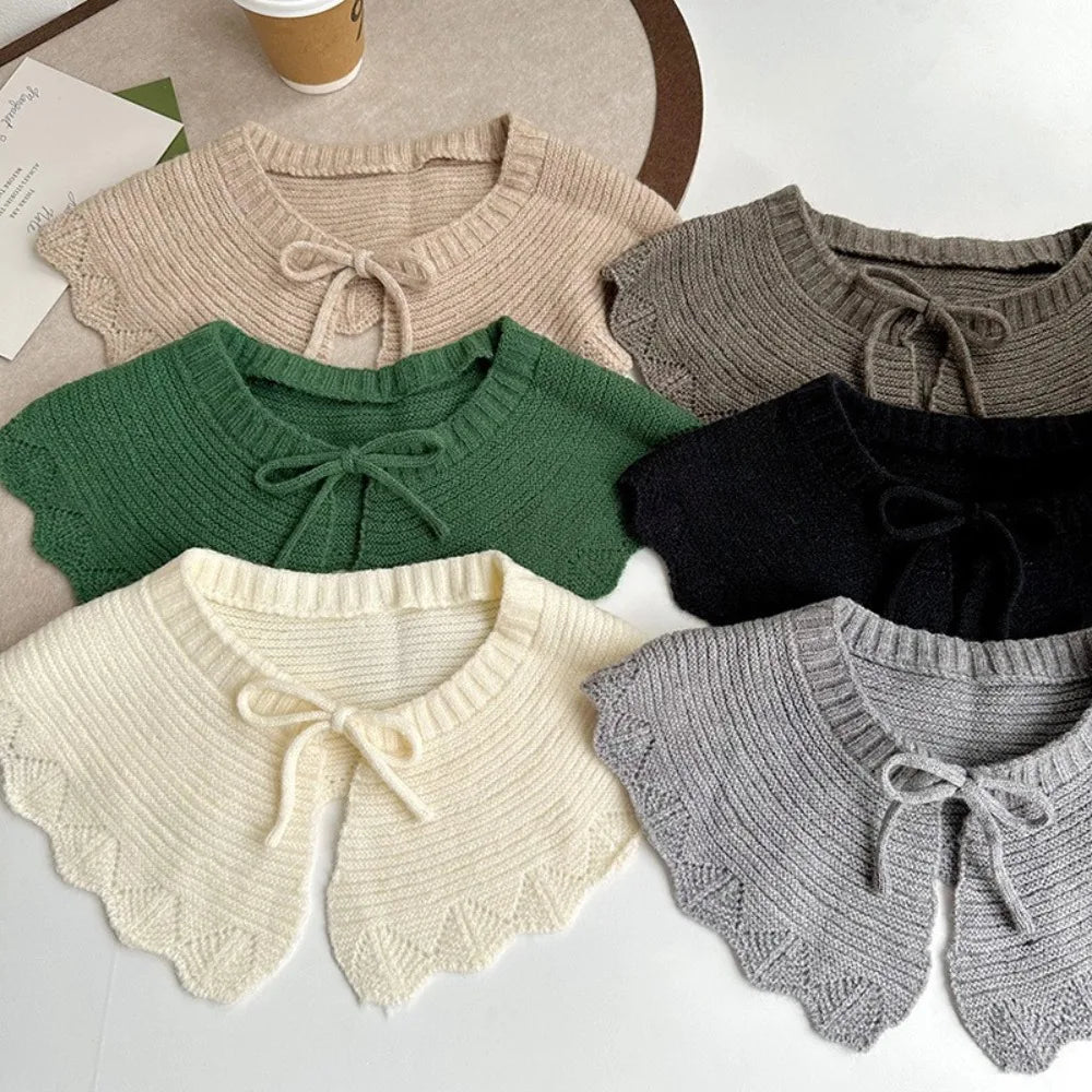 Six knitted collar scarves in beige, green, black, cream, and gray, arranged in a flat-lay pattern on a light surface.