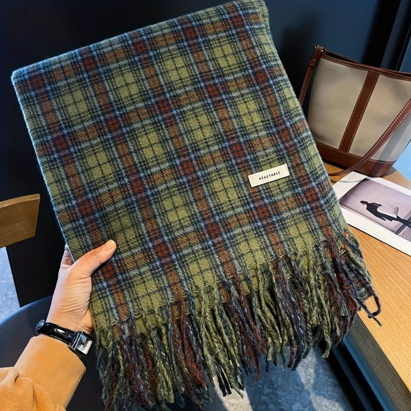 Plaid scarf held by a hand with a visible brand label, placed on a surface.