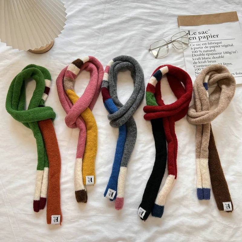 Set of colorful scarves on a white surface with a magazine and glasses.