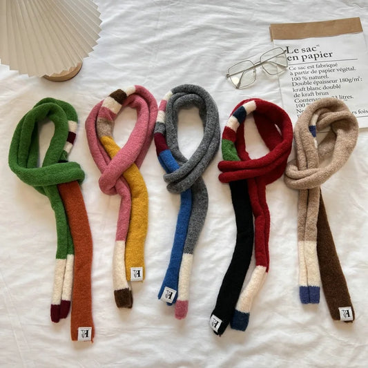 Set of colorful scarves on a white surface with a magazine and glasses.