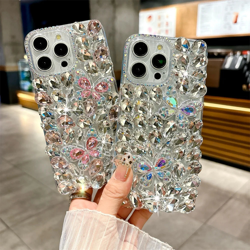 Two crystal phone cases with floral designs held by a hand in an indoor setting.