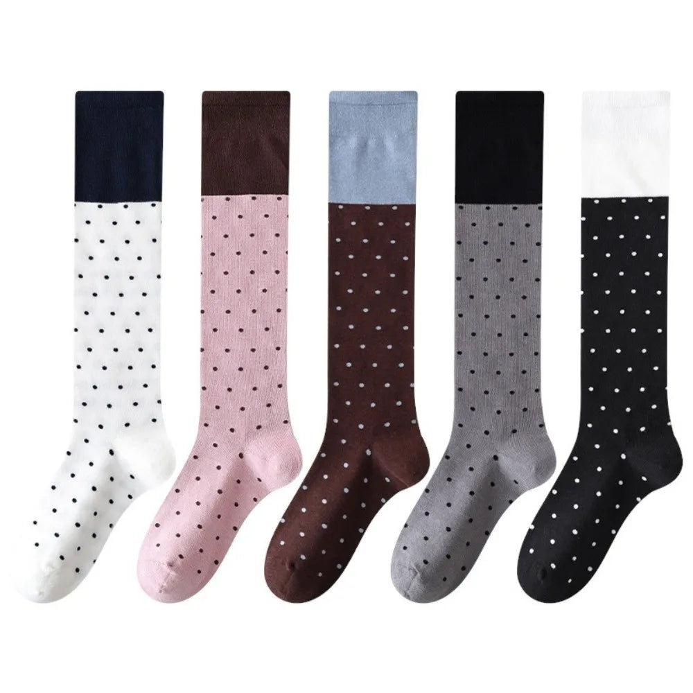 Set of five polka dot socks in various colors on a white background