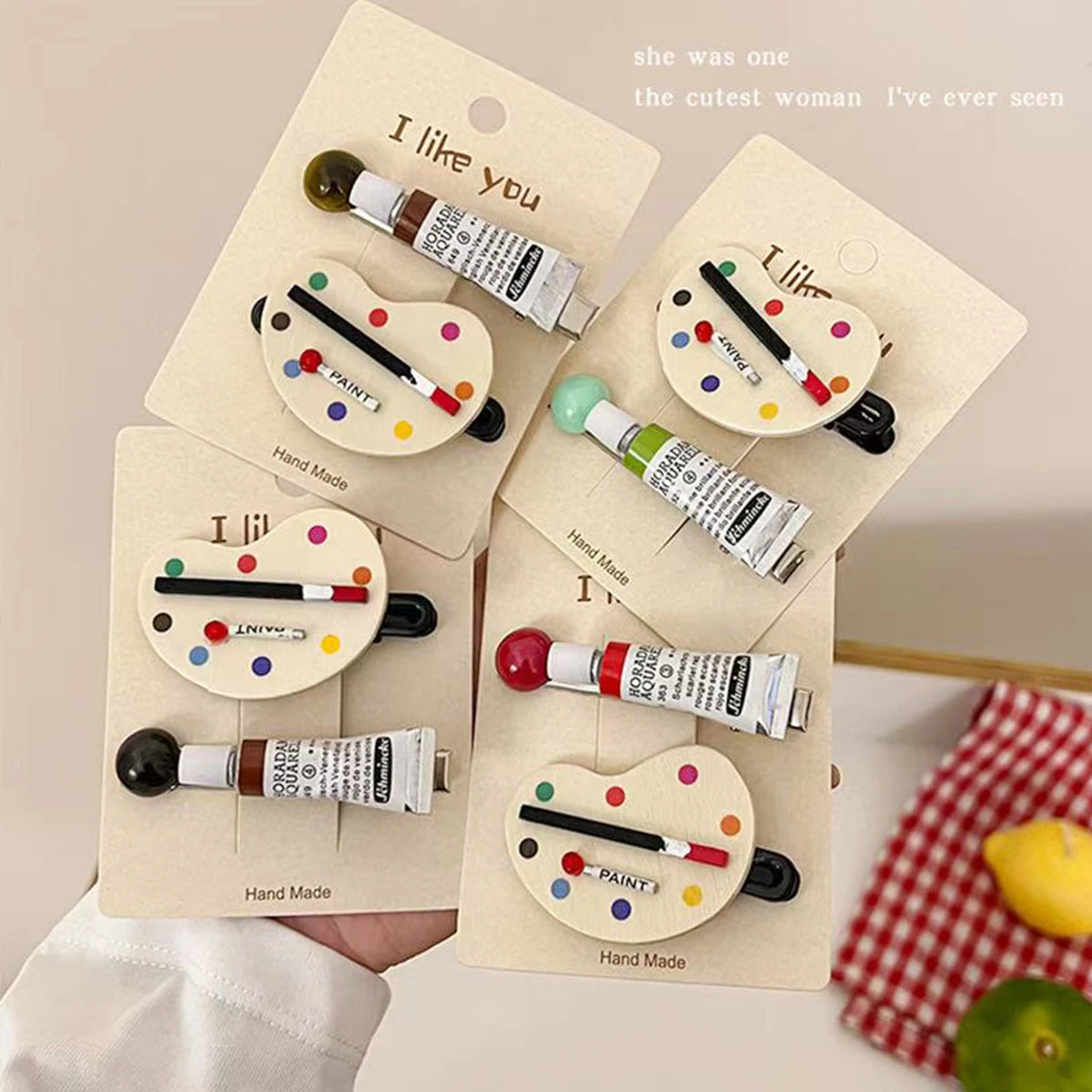Set of paint tube-shaped hair clips on a beige card with 'I like you' text.
