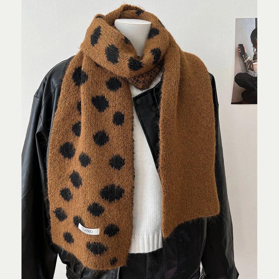 Mannequin wearing a brown scarf with black polka dots against a white background
